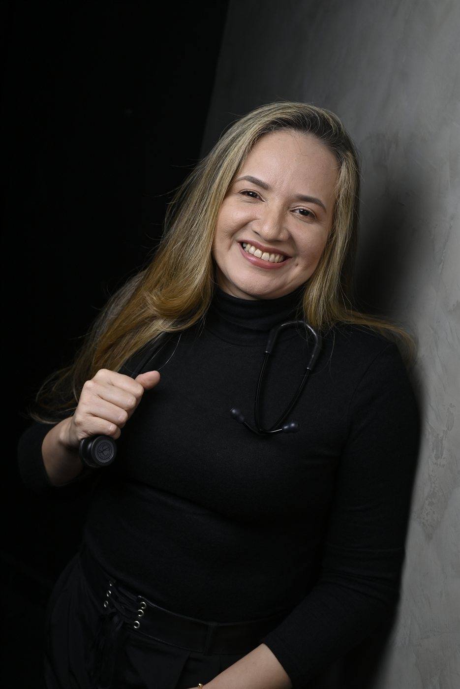 Dra. Elaine Menezes em pose descontraída com estetoscópio